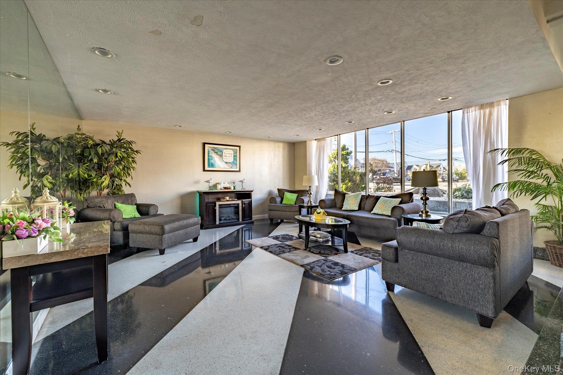 560 West Broadway, Unit 4R Long Beach, NY 11561 - Photo 2 of 26 a living room with furniture large window and potted plants