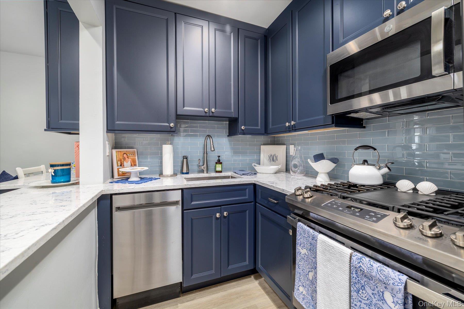 560 West Broadway, Unit 4R Long Beach, NY 11561 - Photo 8 of 26 a kitchen with stainless steel appliances granite countertop a sink stove and microwave