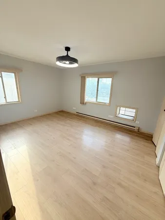 an empty room with a ceiling fan and window