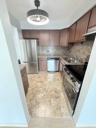 a kitchen with stainless steel appliances granite countertop a sink stove and cabinets