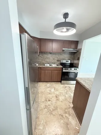 a kitchen with stainless steel appliances a stove a refrigerator and a fireplace