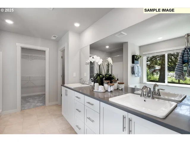 a bathroom with a sink double vanity granite tub shower and a mirror