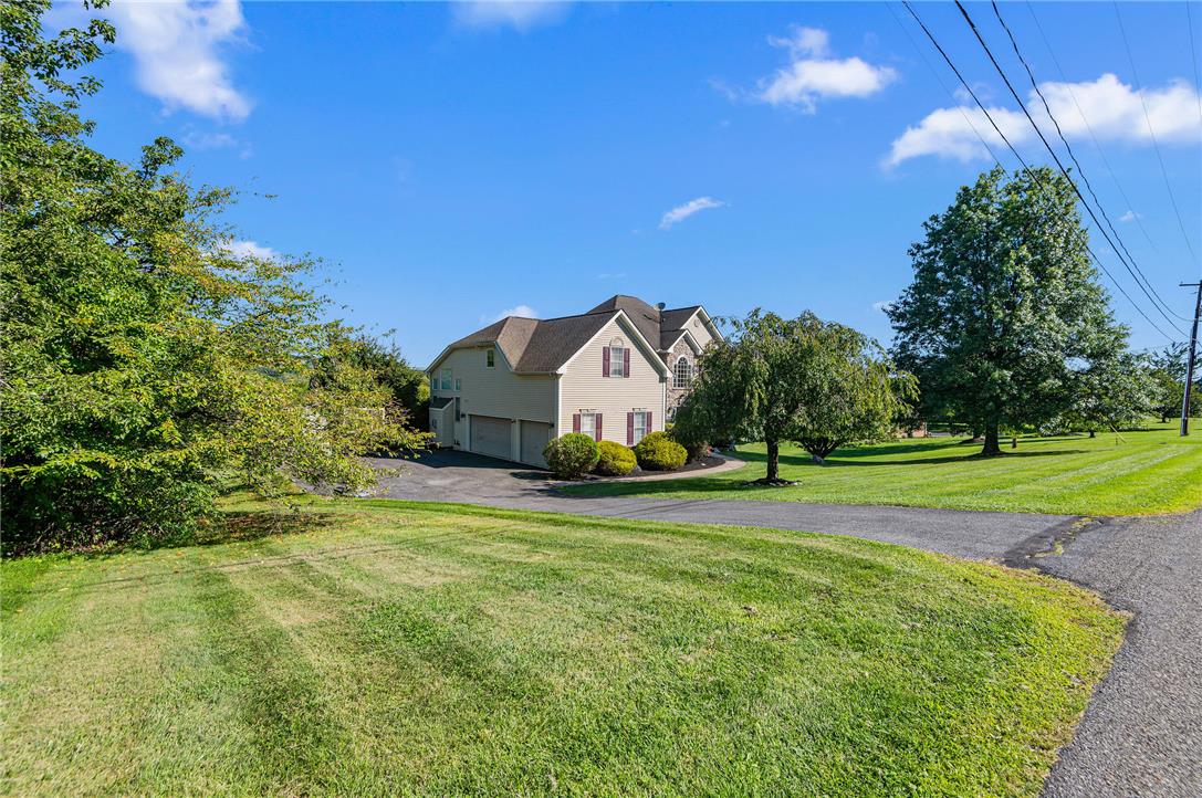2617 Rising Sun Road Slatington, PA 18080 - Photo 58 of 58 Mature trees and vast green lawns frame a stately suburban home with an attached garage.