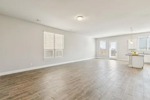 a view of an empty room with glass door and entryway