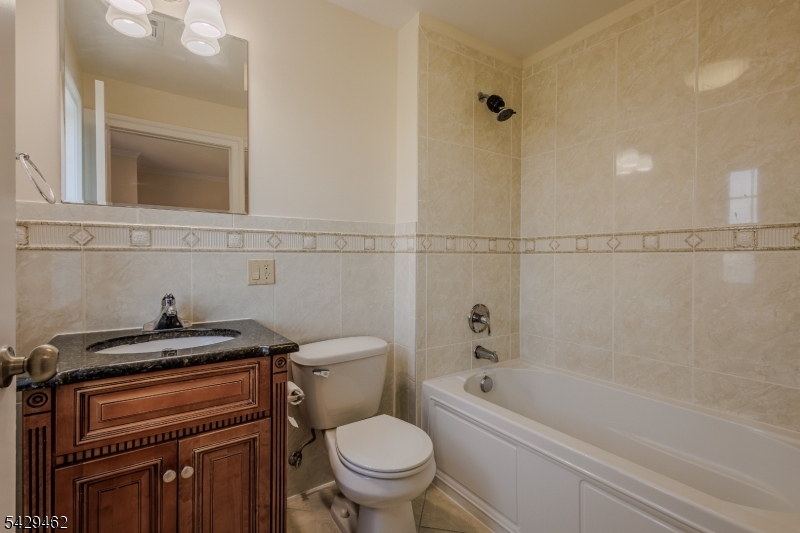 29 Freeman Street, Unit D2 Newark, NJ 07105 - Photo 16 of 29 a bathroom with a granite countertop toilet a sink and bathtub