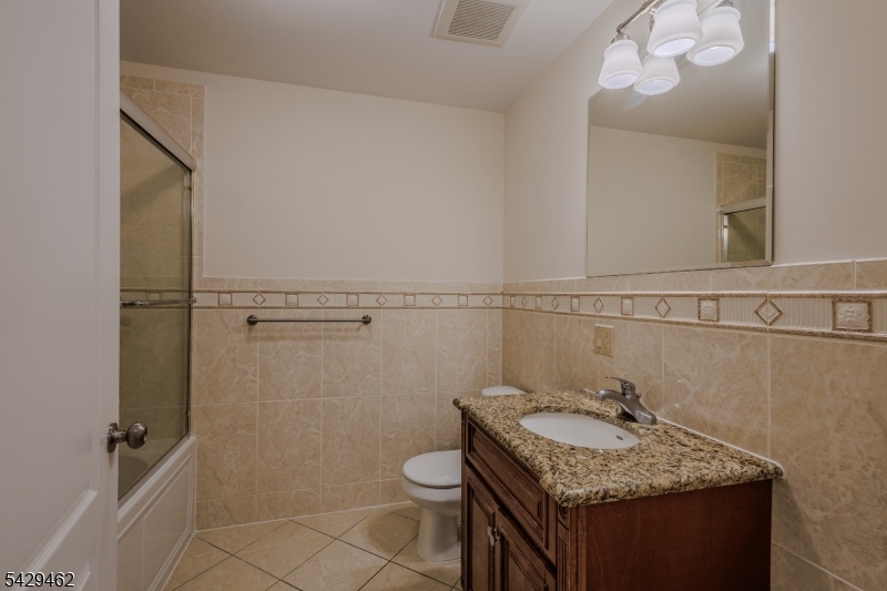 29 Freeman Street, Unit D2 Newark, NJ 07105 - Photo 9 of 29 a bathroom with a granite countertop sink a toilet and a mirror