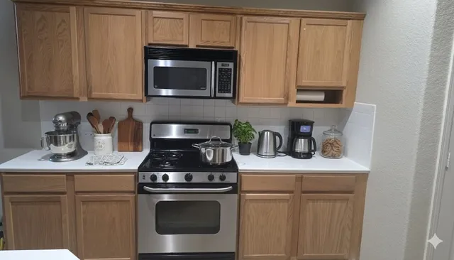 a kitchen with stainless steel appliances granite countertop a sink a stove a microwave oven and cabinets