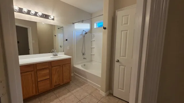 a bathroom with a tub sink shower and mirror