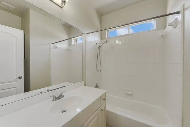 a bathroom with a sink mirror and a bathtub