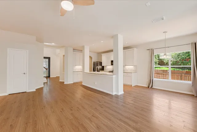 a view of a kitchen with wooden floor and a window