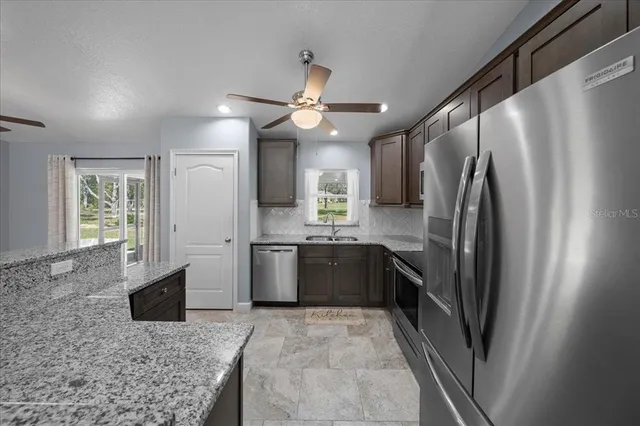 a large kitchen with a large counter top space appliances and cabinets