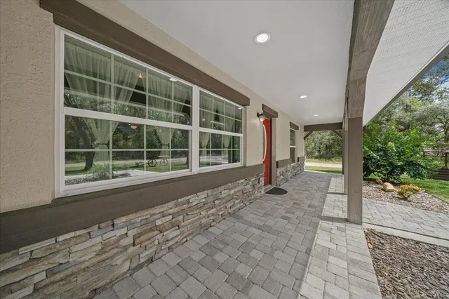 a view of empty room with wooden floor and floor to ceiling window