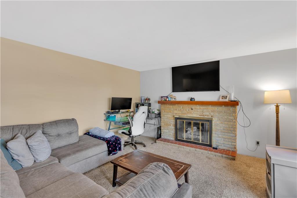 491 South Eberhart Road Butler, PA 16001 - Photo 5 of 33 a living room with furniture a fireplace and a flat screen tv