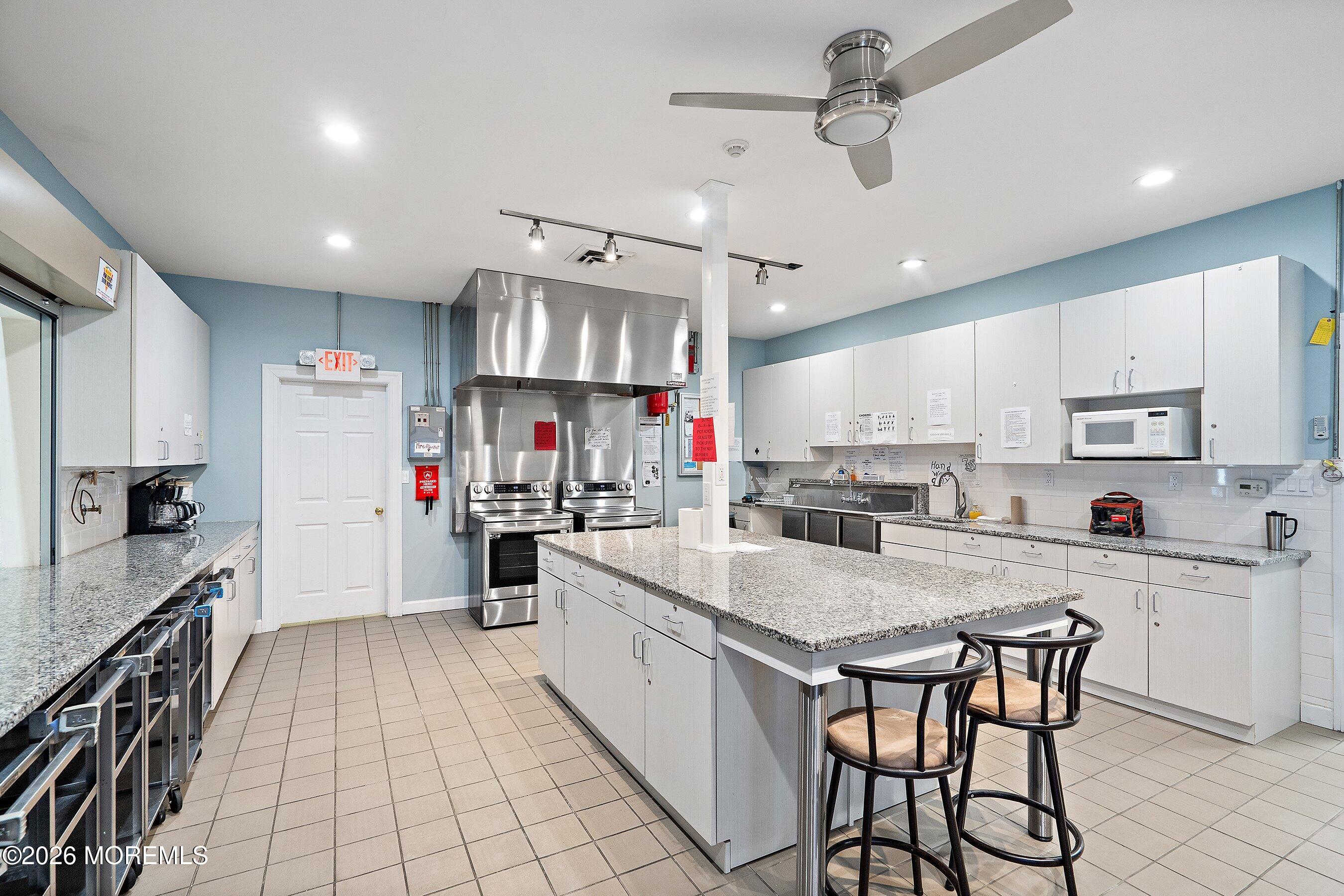 2 Berry Hill Road, Unit 72 Whiting, NJ 08759 - Photo 35 of 43 a kitchen with kitchen island a counter top space a sink stainless steel appliances and cabinets
