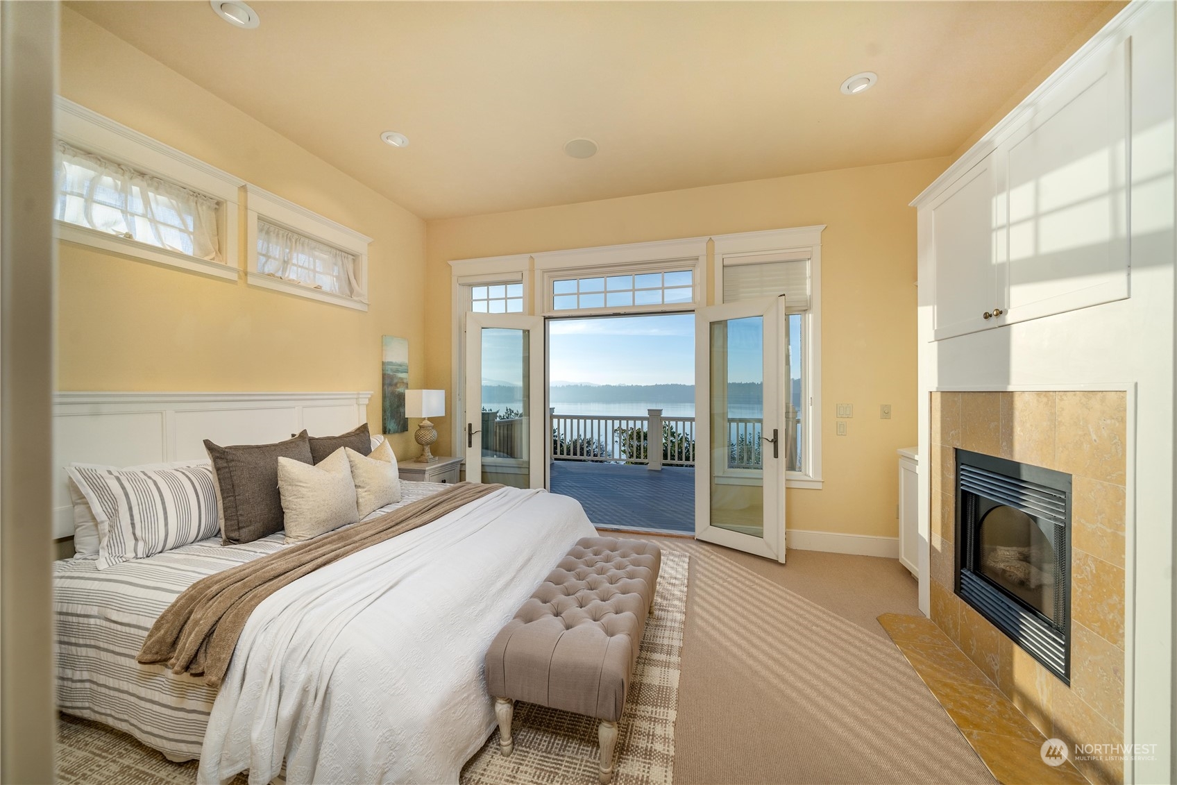 4141 Boston Harbor Road Northeast Olympia, WA 98506 - Photo 26 of 40 a bedroom with a balcony a bed and a fireplace