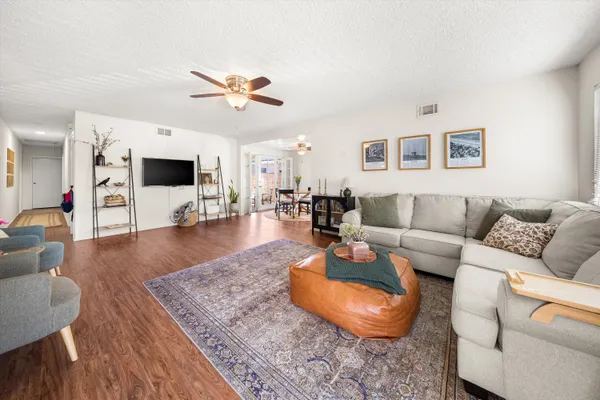 a living room with furniture and a wooden floor