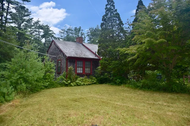 a view of a big house with plants and large trees