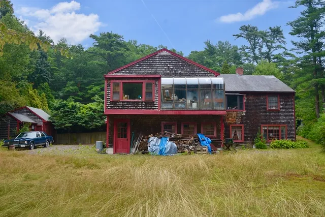 a front view of a house with garden and sitting area