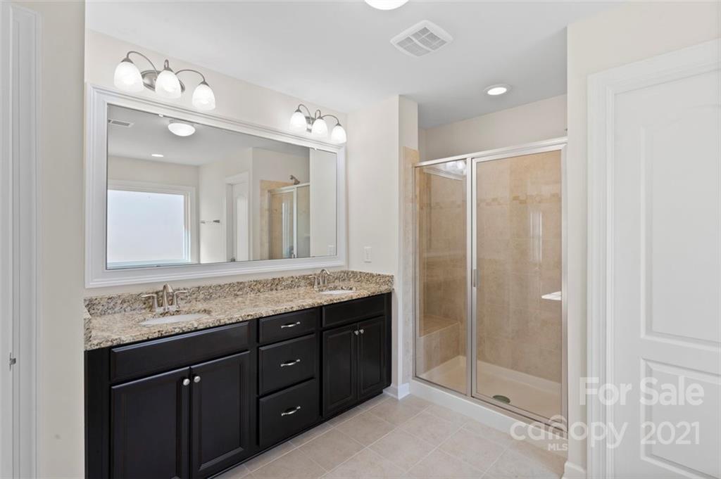 4331 Oxford Mill Road Waxhaw, NC 28173 - Photo 25 of 48 a bathroom with a granite countertop sink a mirror and a shower