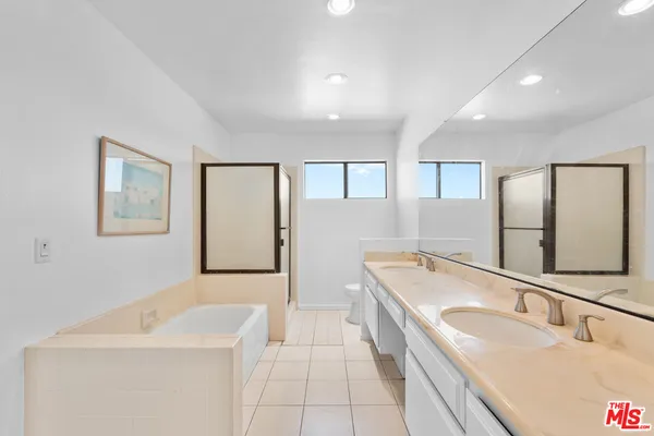 a bathroom with a tub sink and mirror