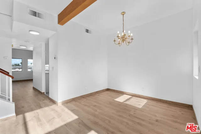 a very nice looking room with wooden floor and a chandelier