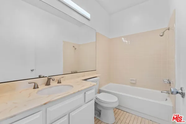 a bathroom with a granite countertop sink a toilet and bathtub
