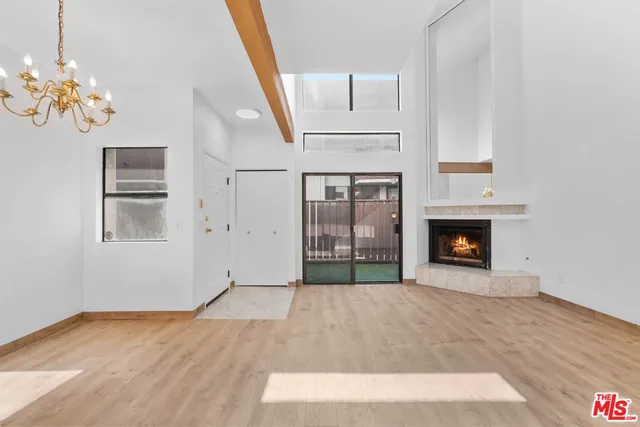 a view of empty room with fireplace and wooden floor