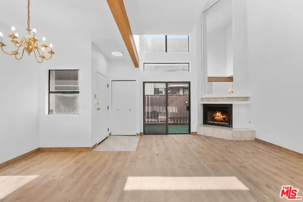a view of empty room with fireplace and wooden floor
