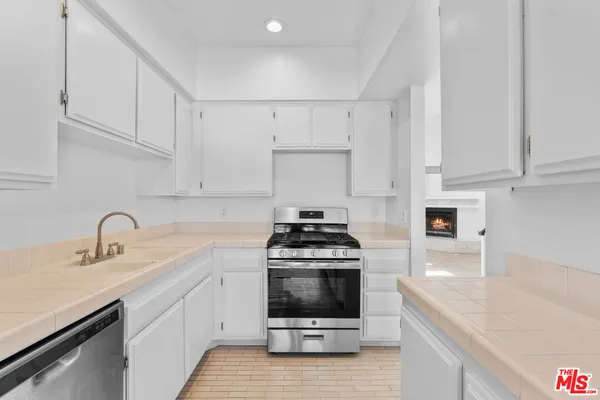 a kitchen with a sink a stove and cabinets