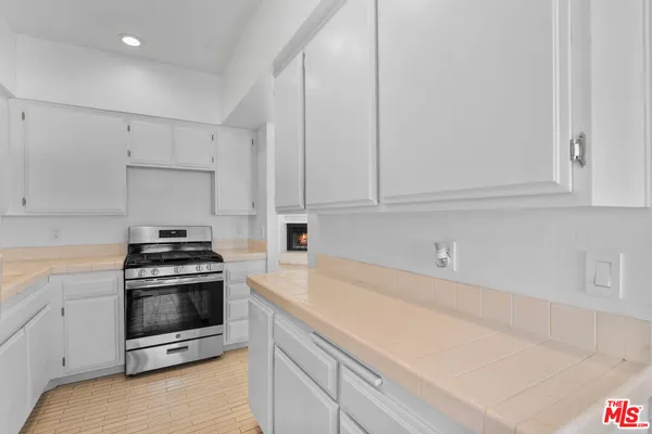 a kitchen with granite countertop white cabinets and stainless steel appliances