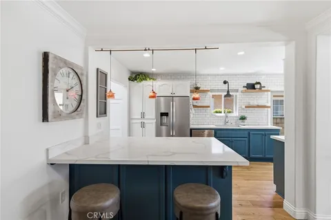 a kitchen with stainless steel appliances granite countertop a sink and wooden cabinets