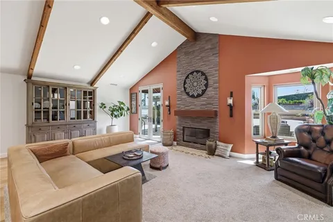 a living room with furniture and a refrigerator