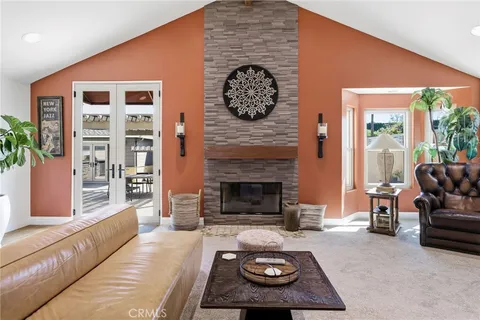 a kitchen with stainless steel appliances granite countertop a refrigerator a stove a sink and white cabinets with wooden floor