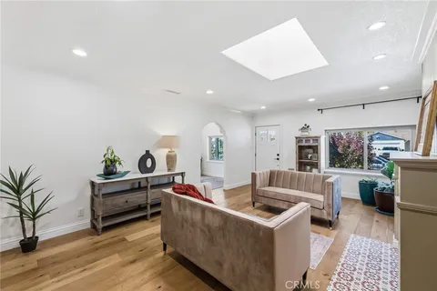 a living room with furniture a flat screen tv and a floor to ceiling window