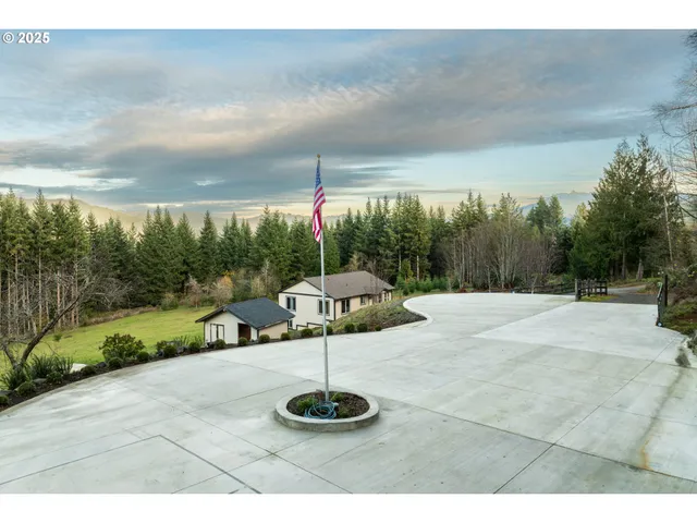 a view of a house with a big yard and large trees