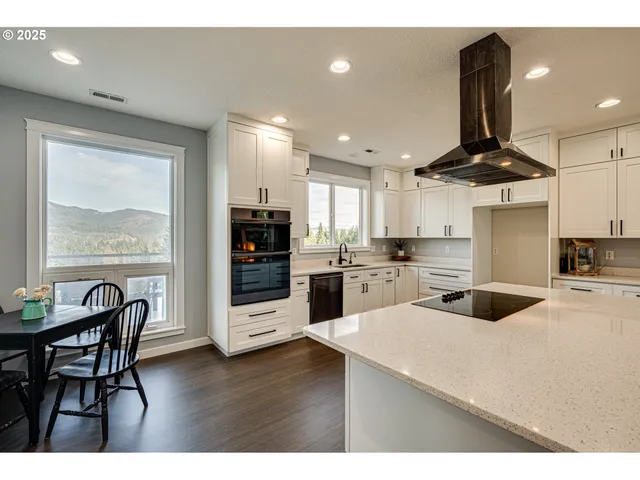 a kitchen with stainless steel appliances kitchen island granite countertop a table and chairs in it