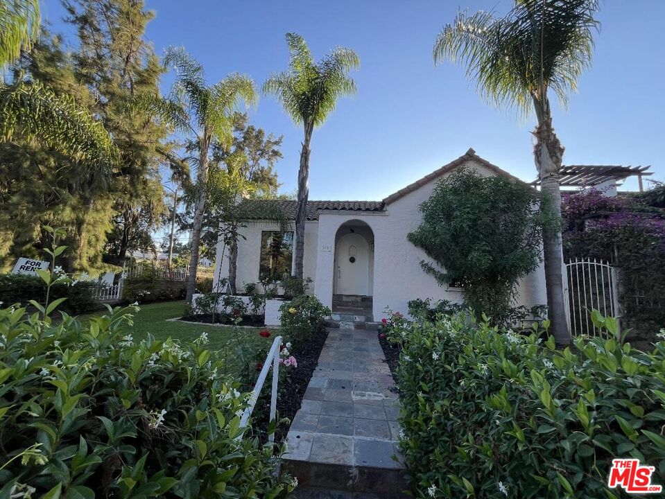 101 North La Peer Drive Los Angeles, CA 90048 - Photo 1 of 33 a front view of a house with a yard and potted plants