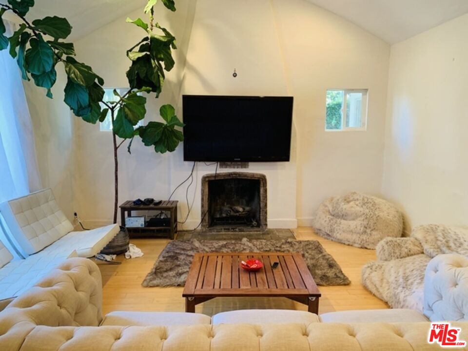 101 North La Peer Drive Los Angeles, CA 90048 - Photo 23 of 33 a living room with furniture fireplace and a potted plant