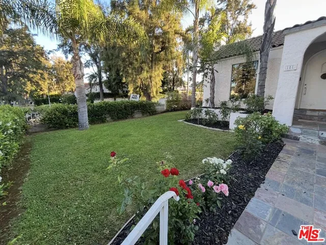 a view of a garden with flowers and trees