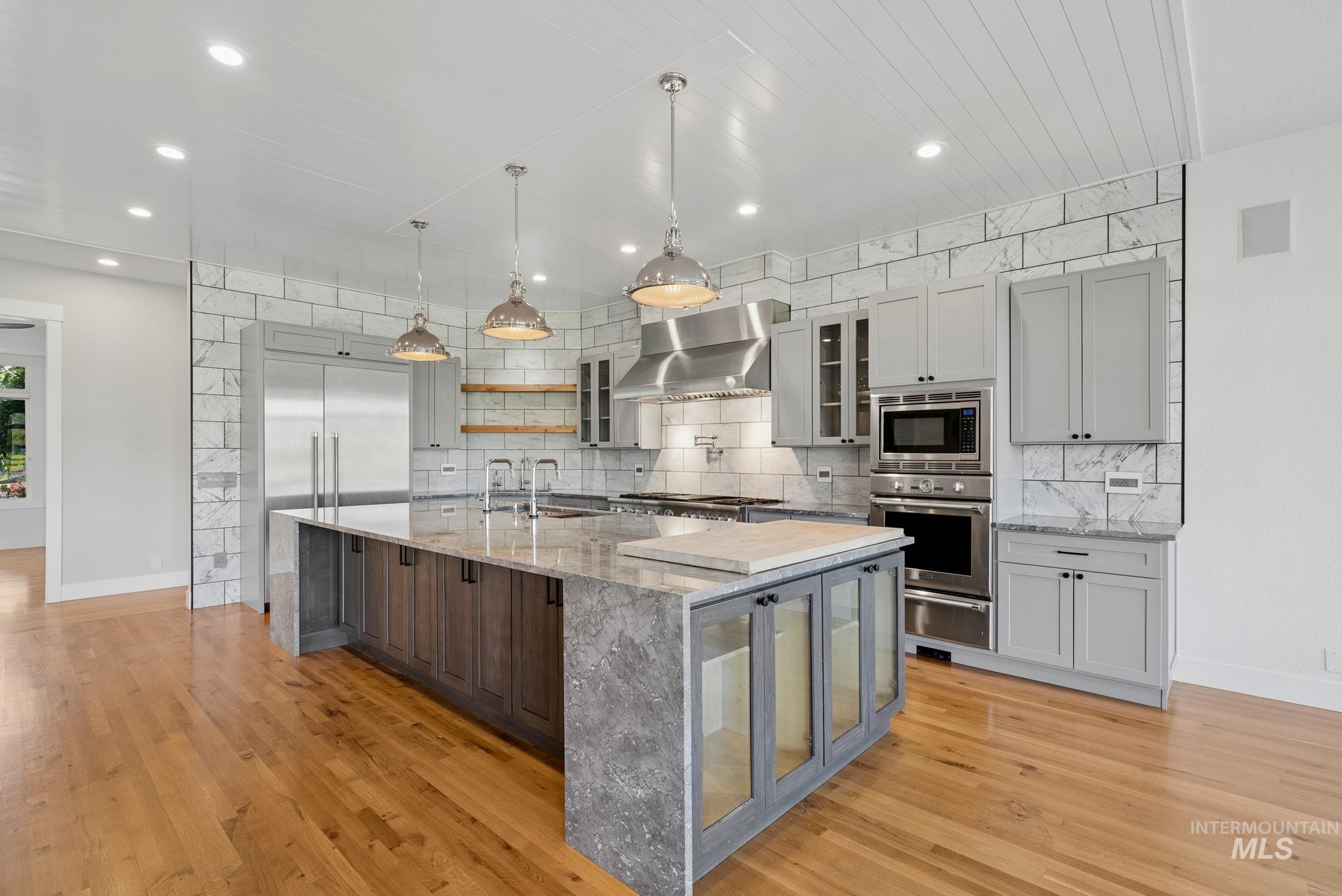 2050 Artesian Road Eagle, ID 83616 - Photo 12 of 49 Open-concept kitchen featuring an oversized island with a butcher block accent, stainless steel appliances, and a subway tile backsplash