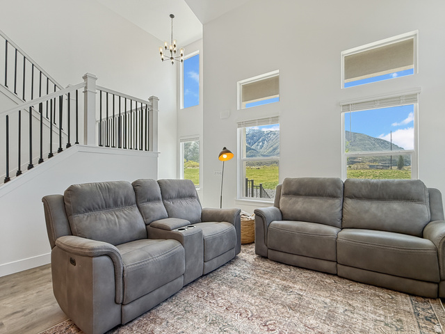 641 Desert Willow Drive Mapleton, UT 84664 - Photo 7 of 41 Living area featuring a high ceiling, light wood-style flooring, a chandelier, and a mountain view
