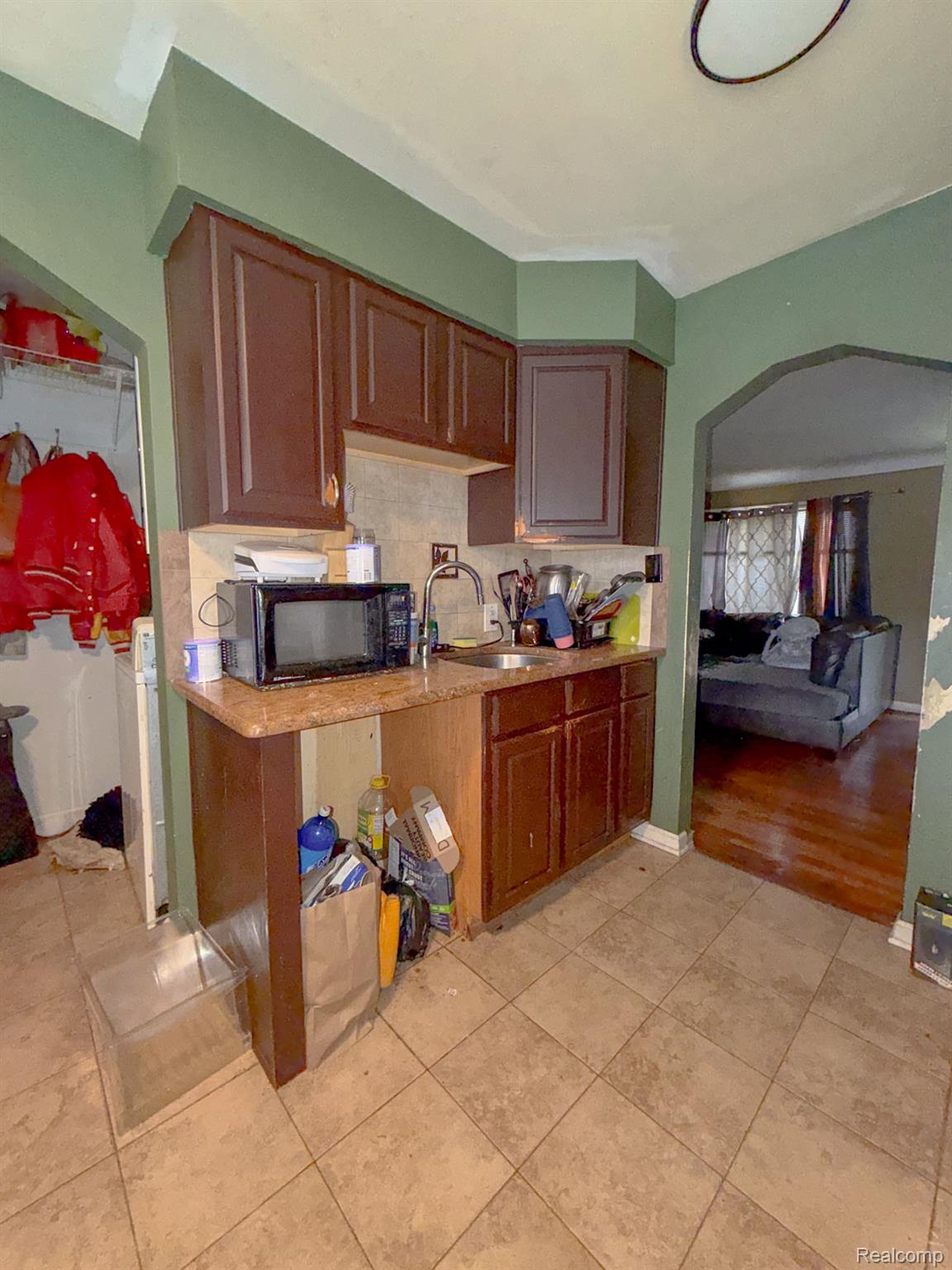 24811 Valley Avenue Eastpointe, MI 48021 - Photo 6 of 22 Kitchen with backsplash, arched walkways, light countertops, and light tile patterned floors