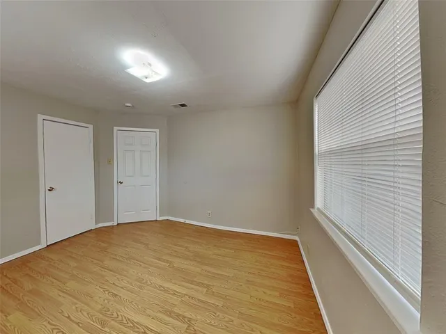 a view of empty room with wooden floor