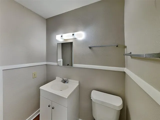 a bathroom with a toilet a sink and mirror