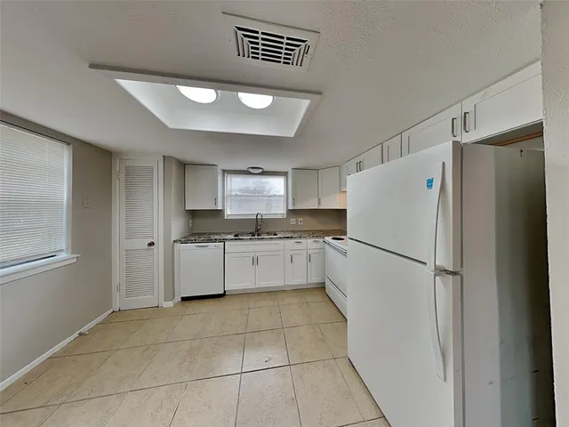 a kitchen with a refrigerator a sink and cabinets