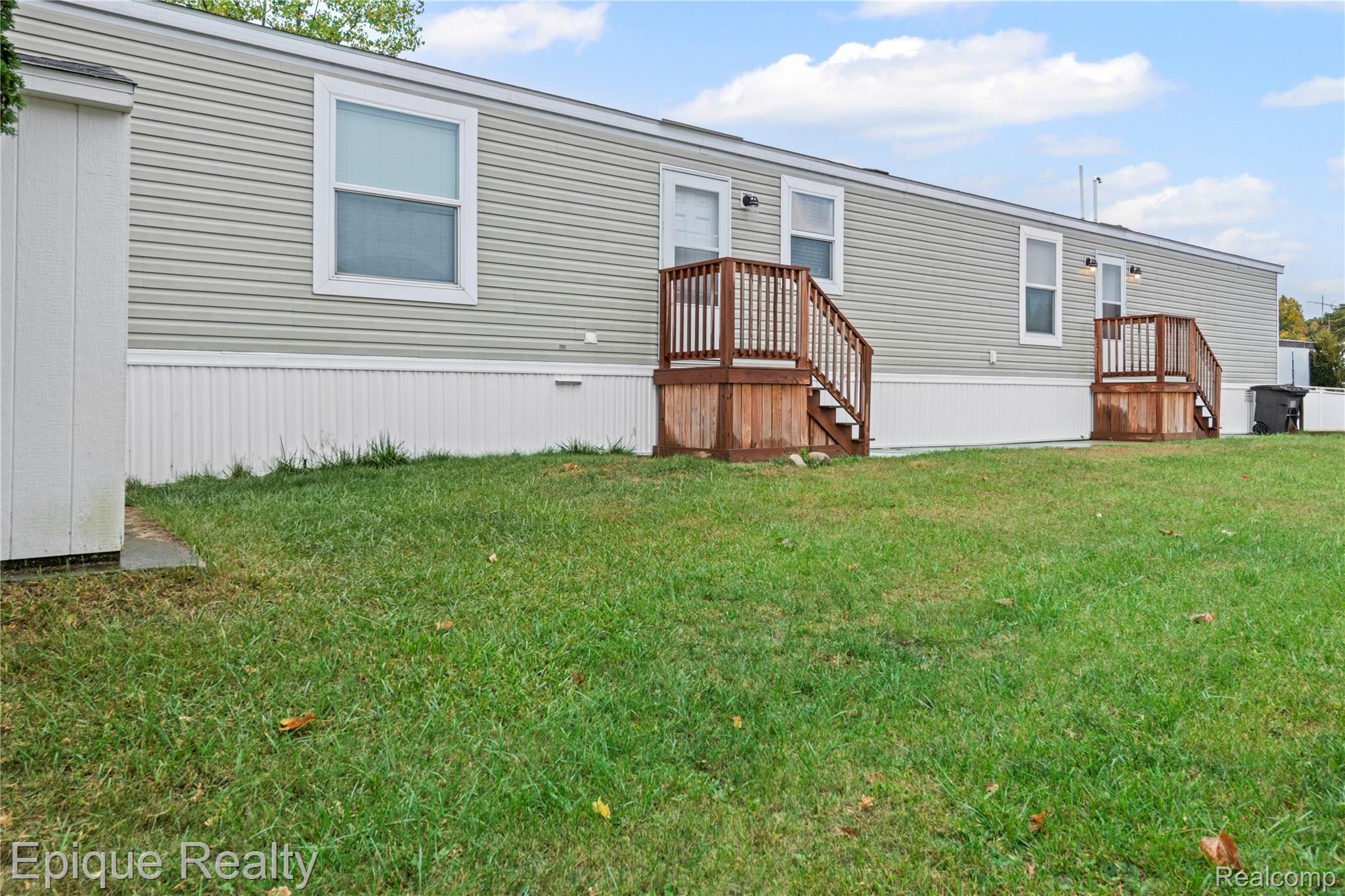 83 Elm Highland, MI 48357 - Photo 2 of 27 Back of house with a lawn