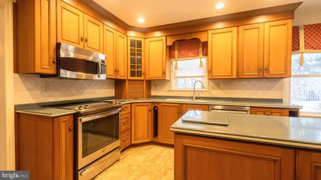 a kitchen with stainless steel appliances granite countertop a stove and a refrigerator