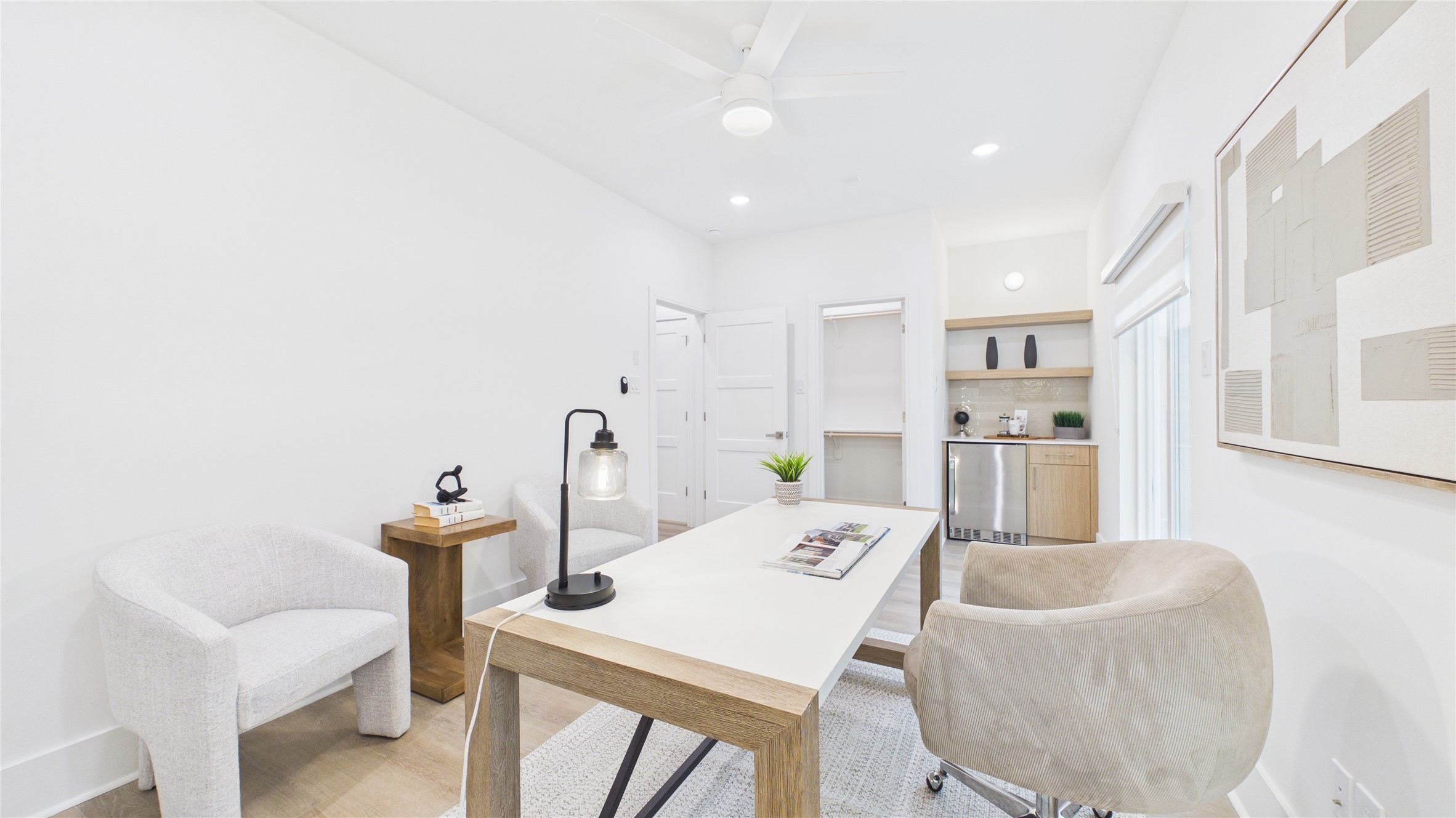 602 Skyland Terrace Way Houston, TX 77009 - Photo 8 of 40 Bright and modern home office with minimalist decor, featuring a sleek desk, comfortable chairs, and ample natural light. The room includes built-in shelving and a small kitchenette area for convenience.