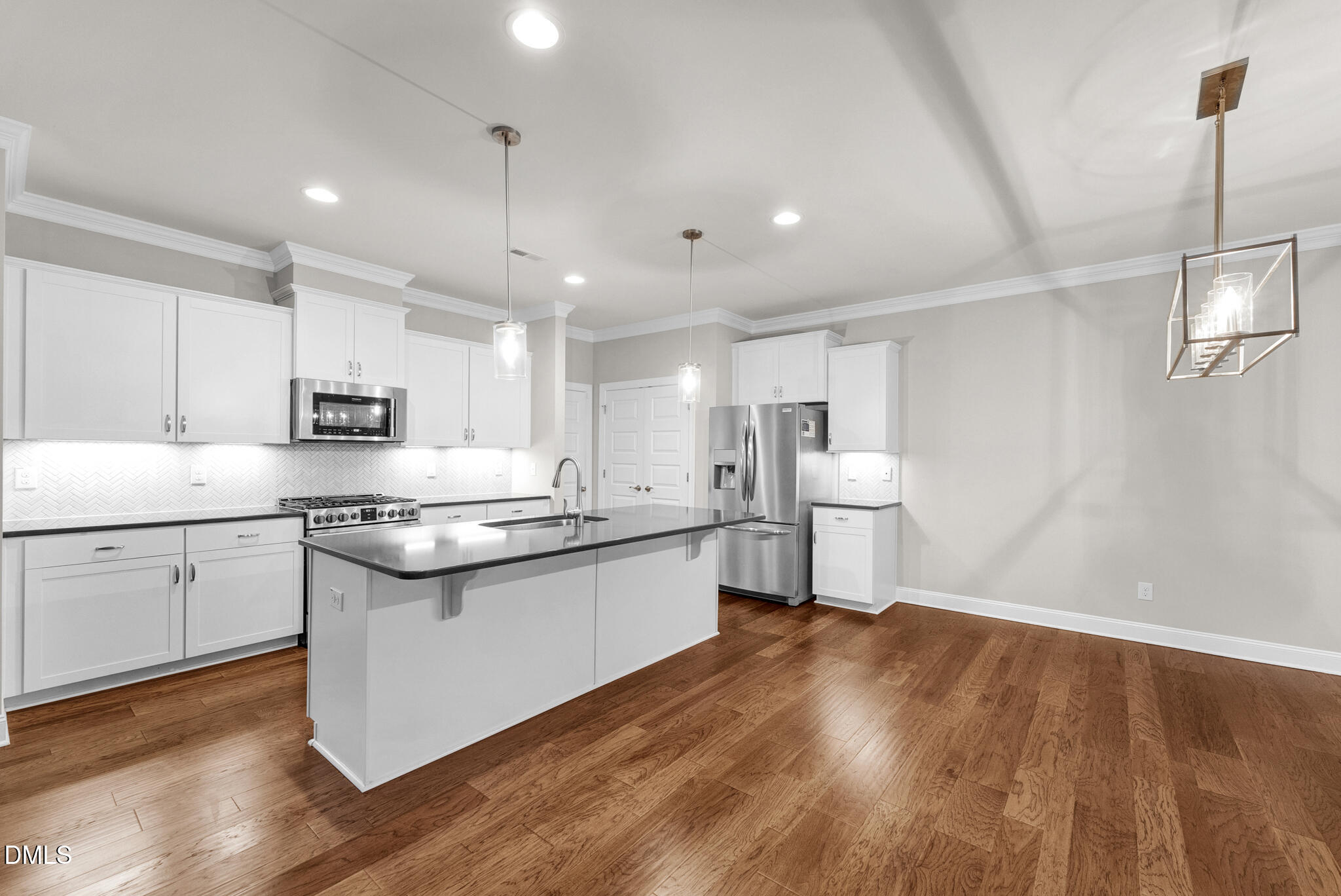 928 Barringer Drive Raleigh, NC 27606 - Photo 5 of 40 a kitchen with stainless steel appliances granite countertop a sink a stove a refrigerator and white cabinets with wooden floor