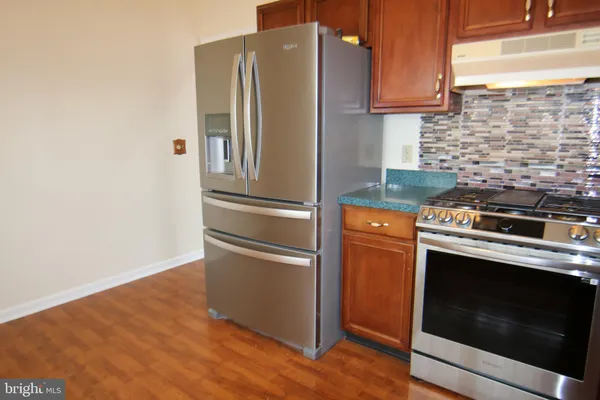 a kitchen with metallic refrigerator and a stove